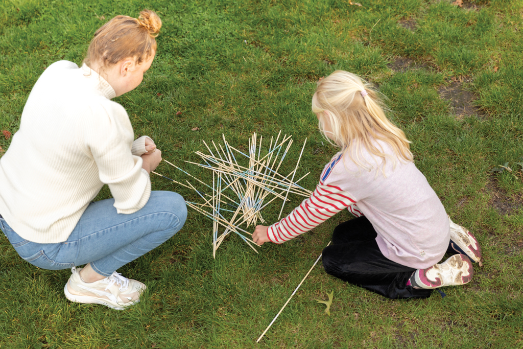 Fädenkonstruktion, Zwei Kinder, Drahtstäbe, Spielen auf Rasen, Kreatives Bauen, holzsticks, holzspitzen, kinder spiel, outdoor spiel, konstruktion, holzstangen, holzstab, kinder spiel, natürliche materialien, grüne wiese